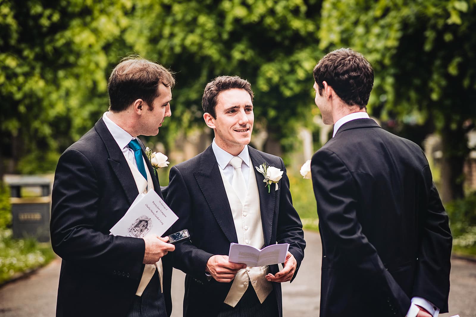 Groom chat's with his groomsmen outside Fulham All Saints Church