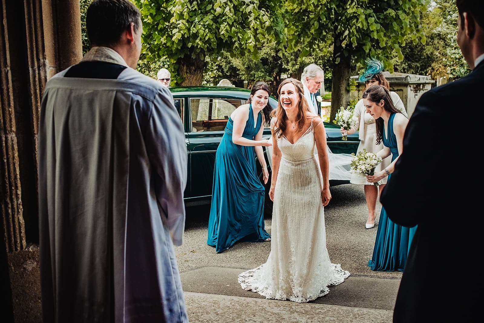 Bride smiles at the vicar as she arrives at her Fulham All Saints Church wedding ceremony