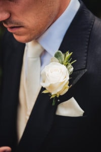 Close up of the Groom and his white rose boutonniere buttonhole