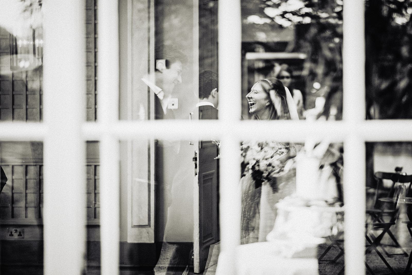 Reflection of the bride laughing with her guests at her summer Hurlingham Club wedding