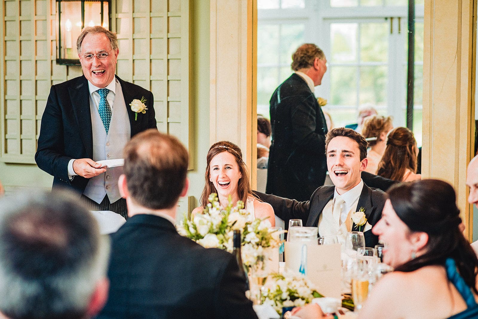 Bride and groom laugh at the Father of the bride's speech at the Hurlingham Club