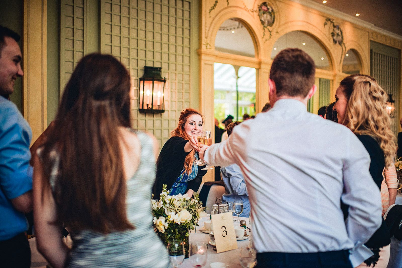 Wedding guests cheer with drinks at the Hurlingham Club