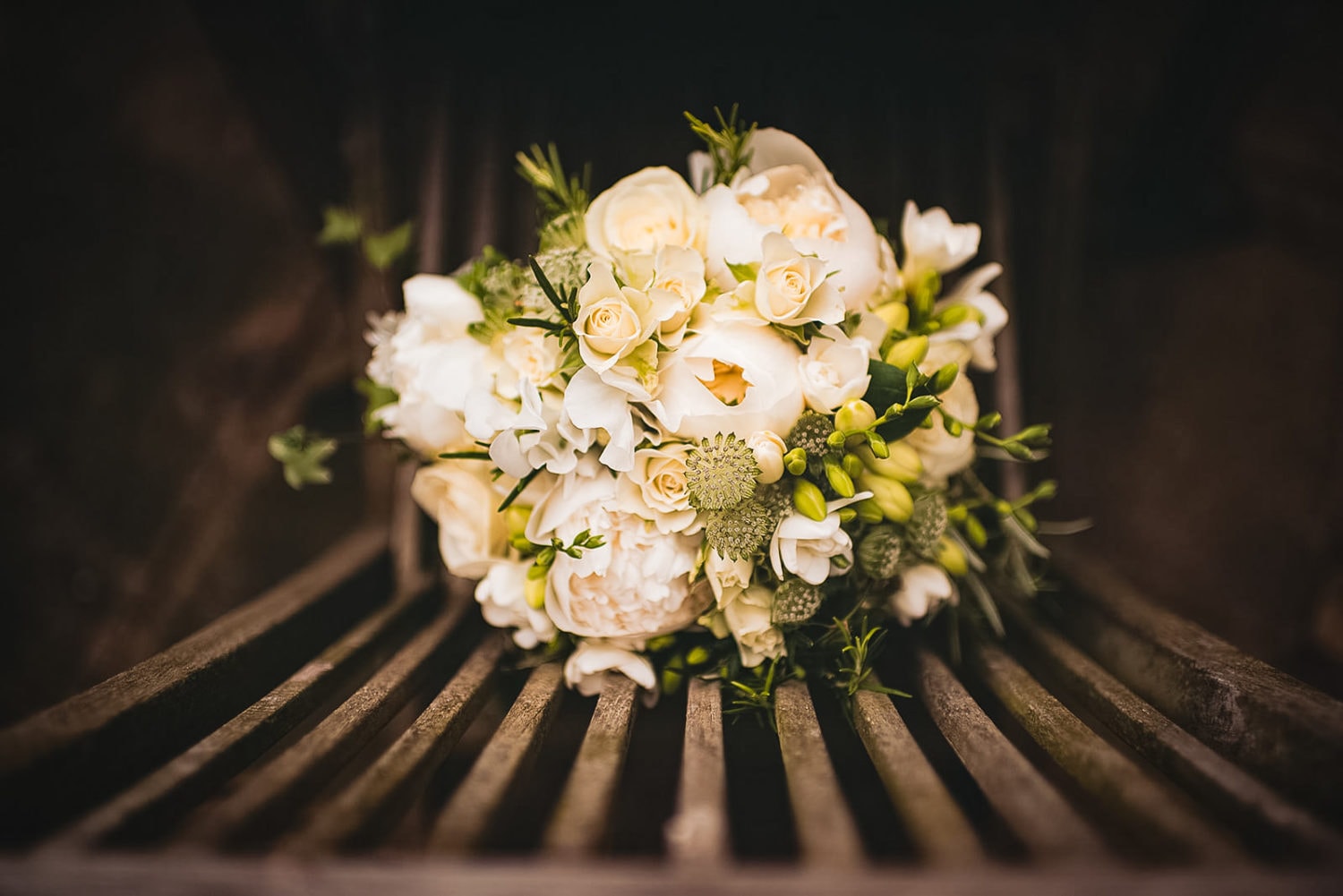 White wedding bouquet with white roses, fresias and peonies