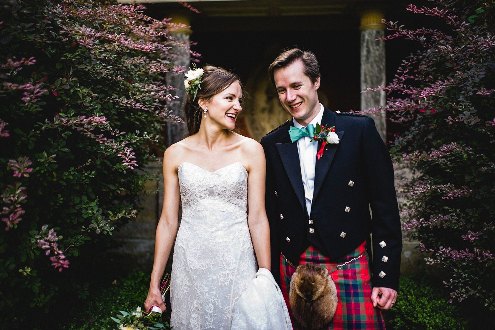 Bride and Scottish groom in a kilt walk together laughing