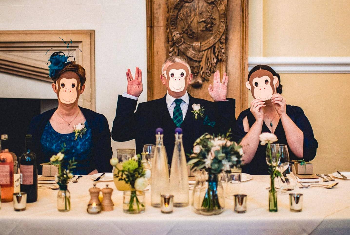 Wedding guests wear monkey masks at a monkey themed Farnham Castle Wedding