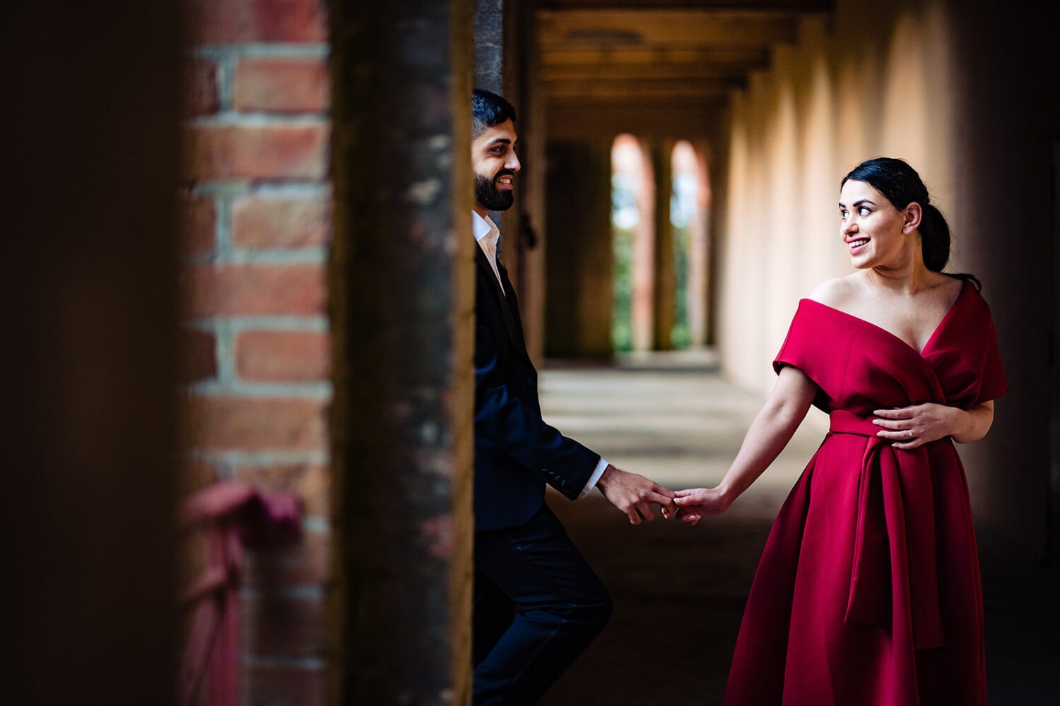 Asian couple smile holding hands at London's iconic Hill Garden and Pergola