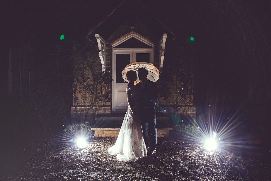 Bride and groom creative light night shot in the rain in front of Smeetham Hall Barn