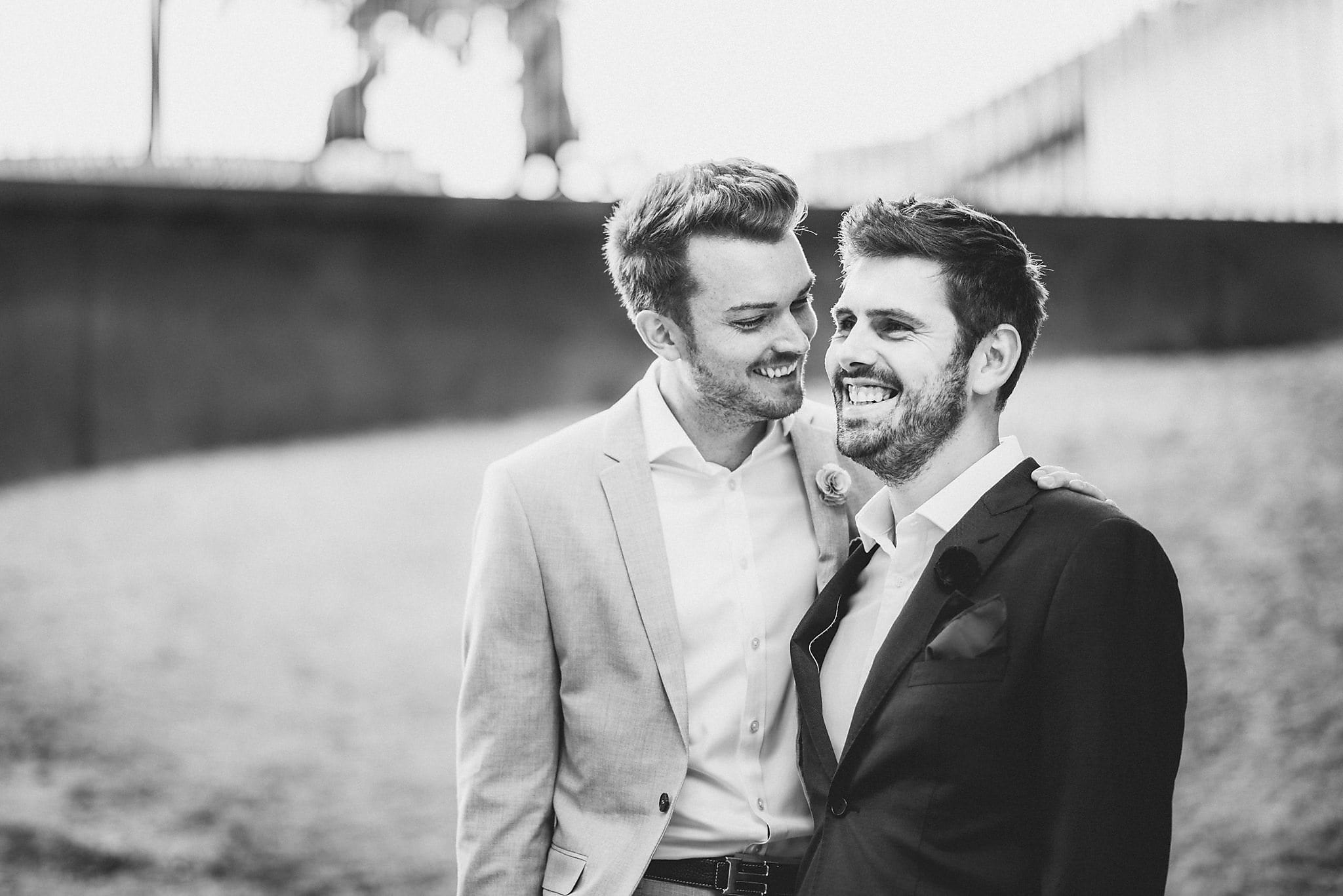 Two grooms laugh together at their Copenhagen Destination Wedding