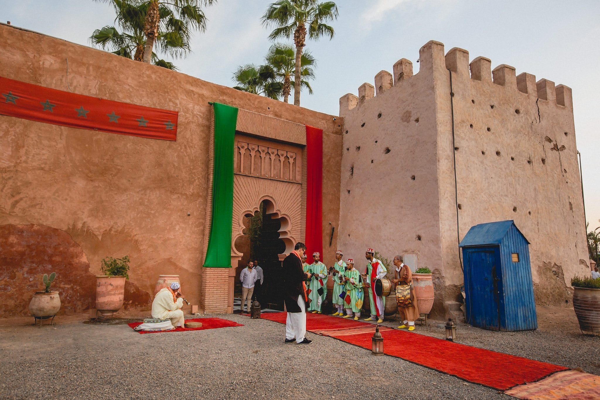 Palais Soleiman in Marrakech with red and green banners and palm trees in the back