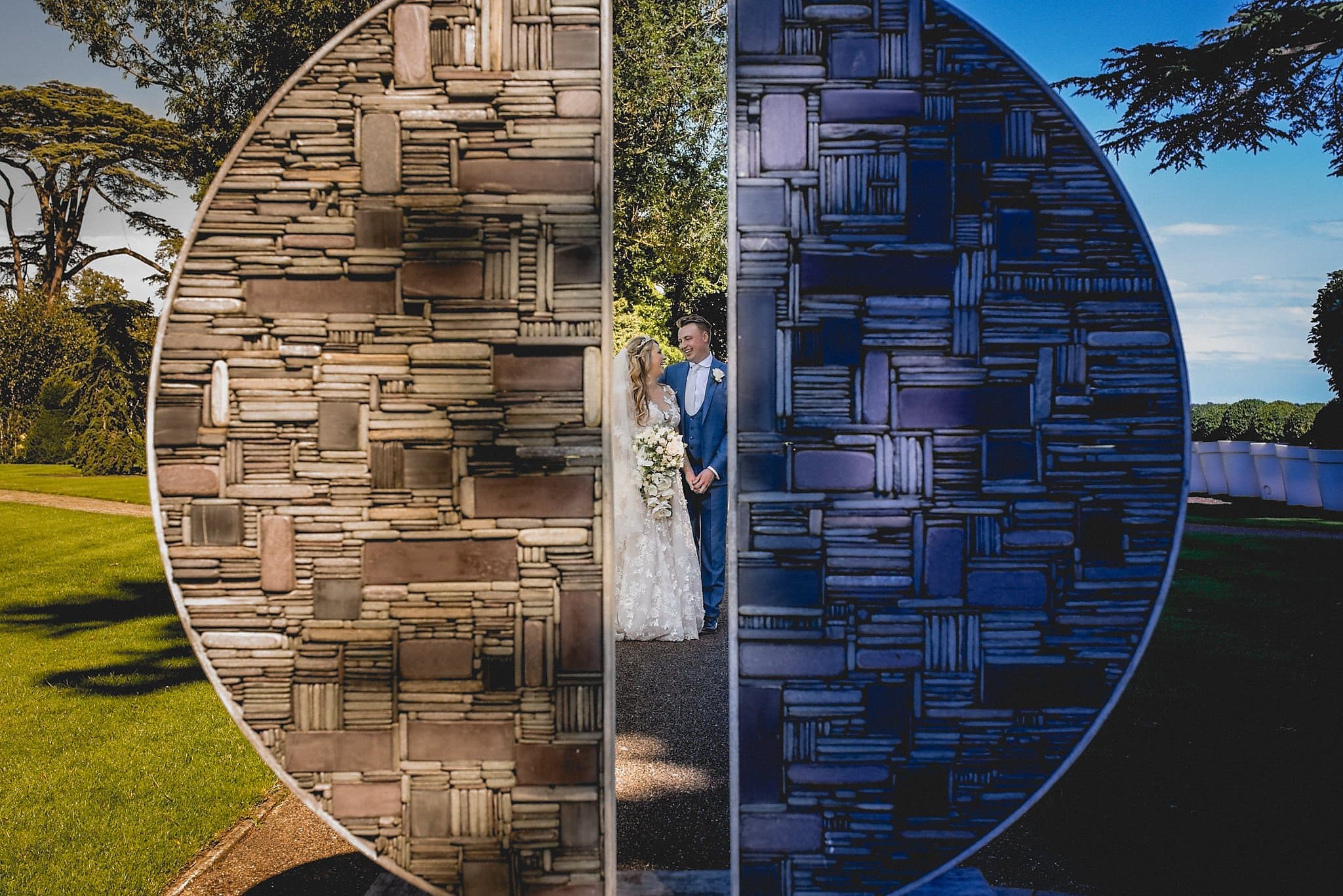 Bride and groom shot through modern sculpture at The Grove hotel Wedding