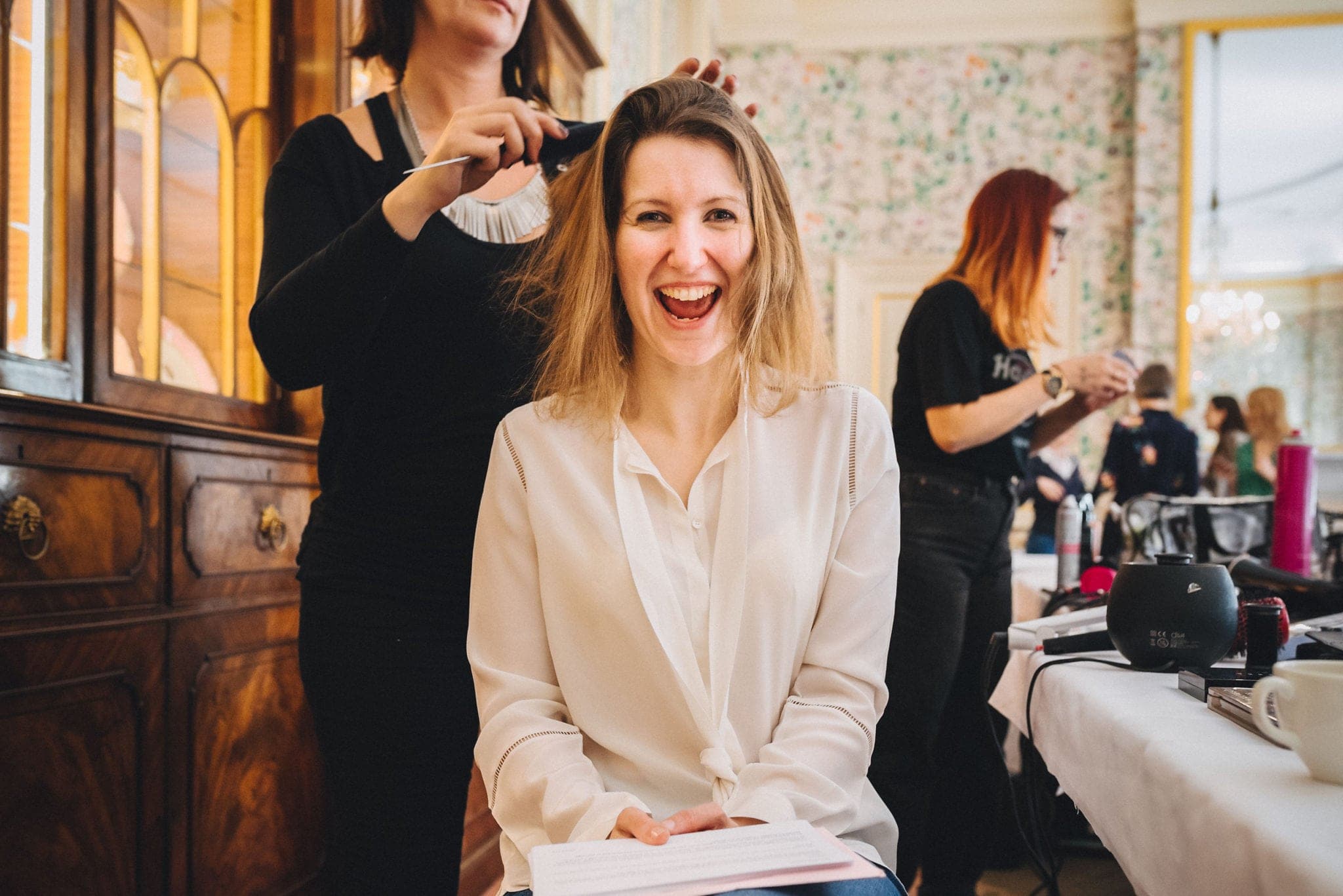 Bride laughs while having her hair done