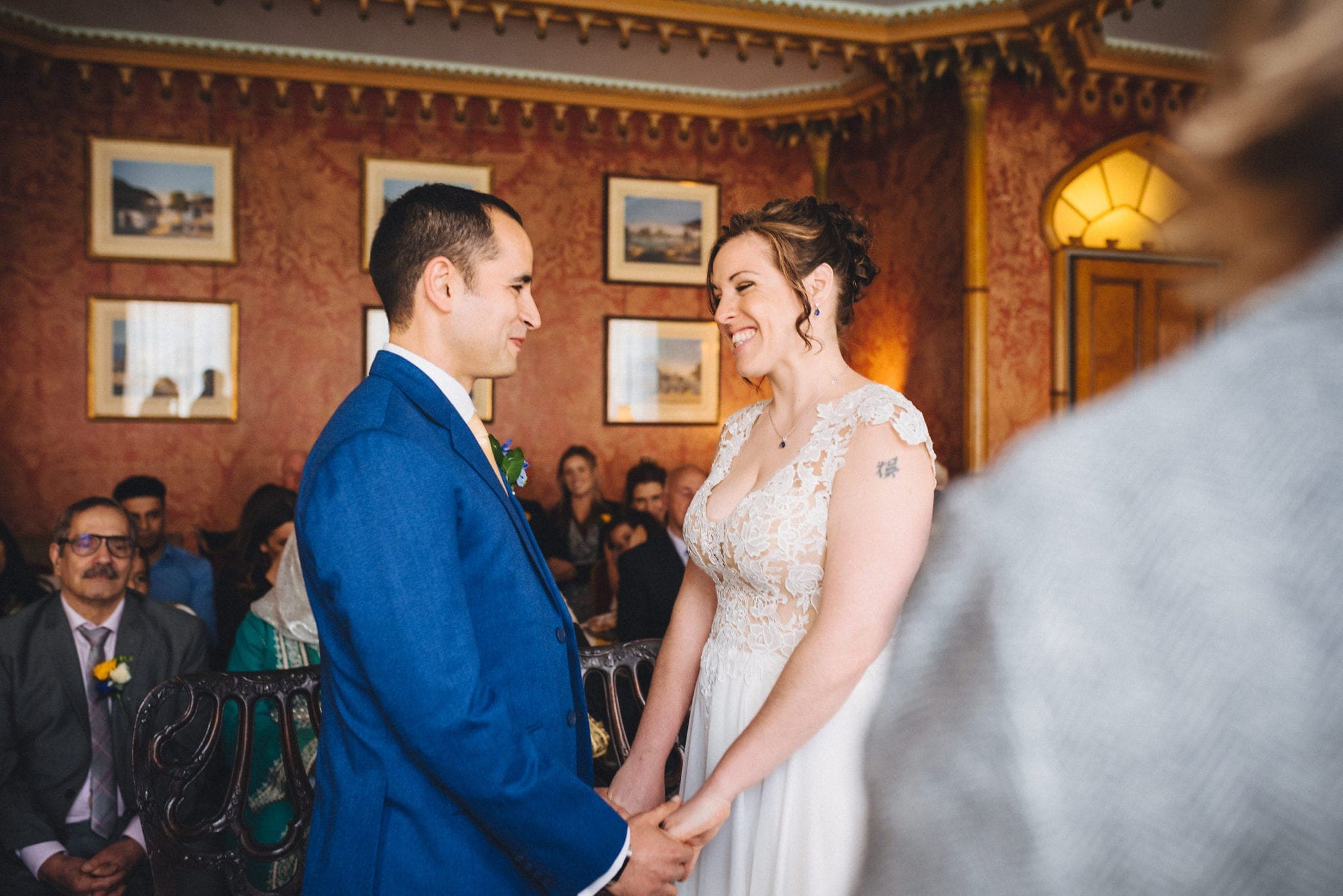 Bride and groom hold hands and laugh during their wedding ceremony