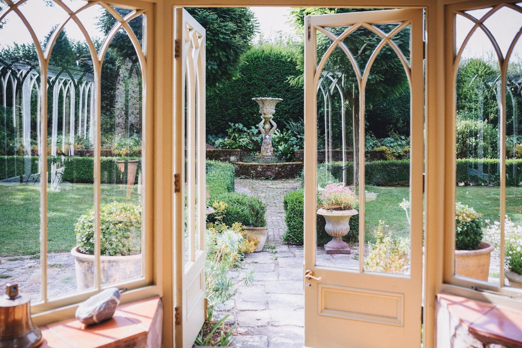 View through the doors out into the gardens at Dewsall Court with stone fountains