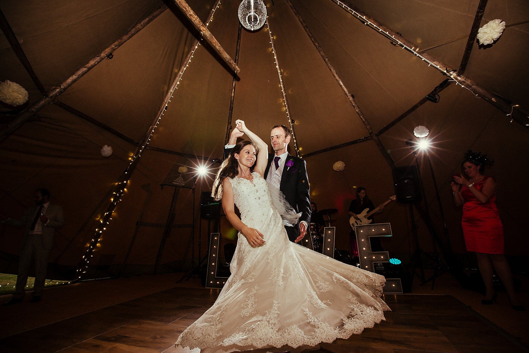 Groom twirls bride on the dance floor during the first dance