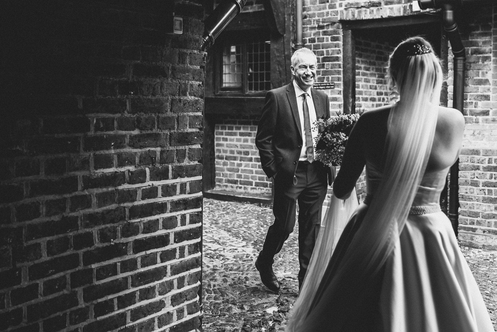 Black and white shot of father of the bride seeing his daughter in her dress for the first time